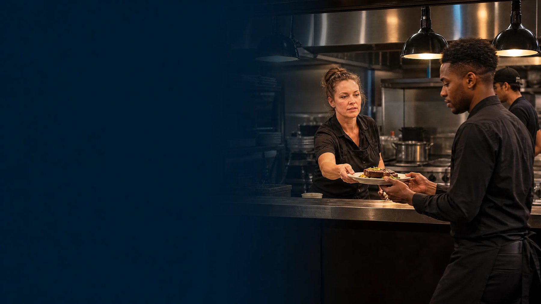 A restaurant service handoff coordinated in a professional kitchen